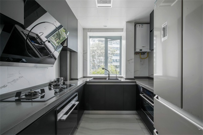 厨房动线规划完整，木质橱柜凸显空间质感，搭配白色工作台，使空间更加通透明亮。