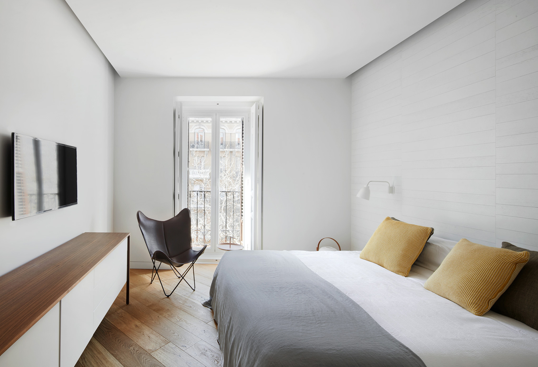 卧室在灰色、白色、木色和浅黄色的对比下，突显了业主对品质生活的追求。