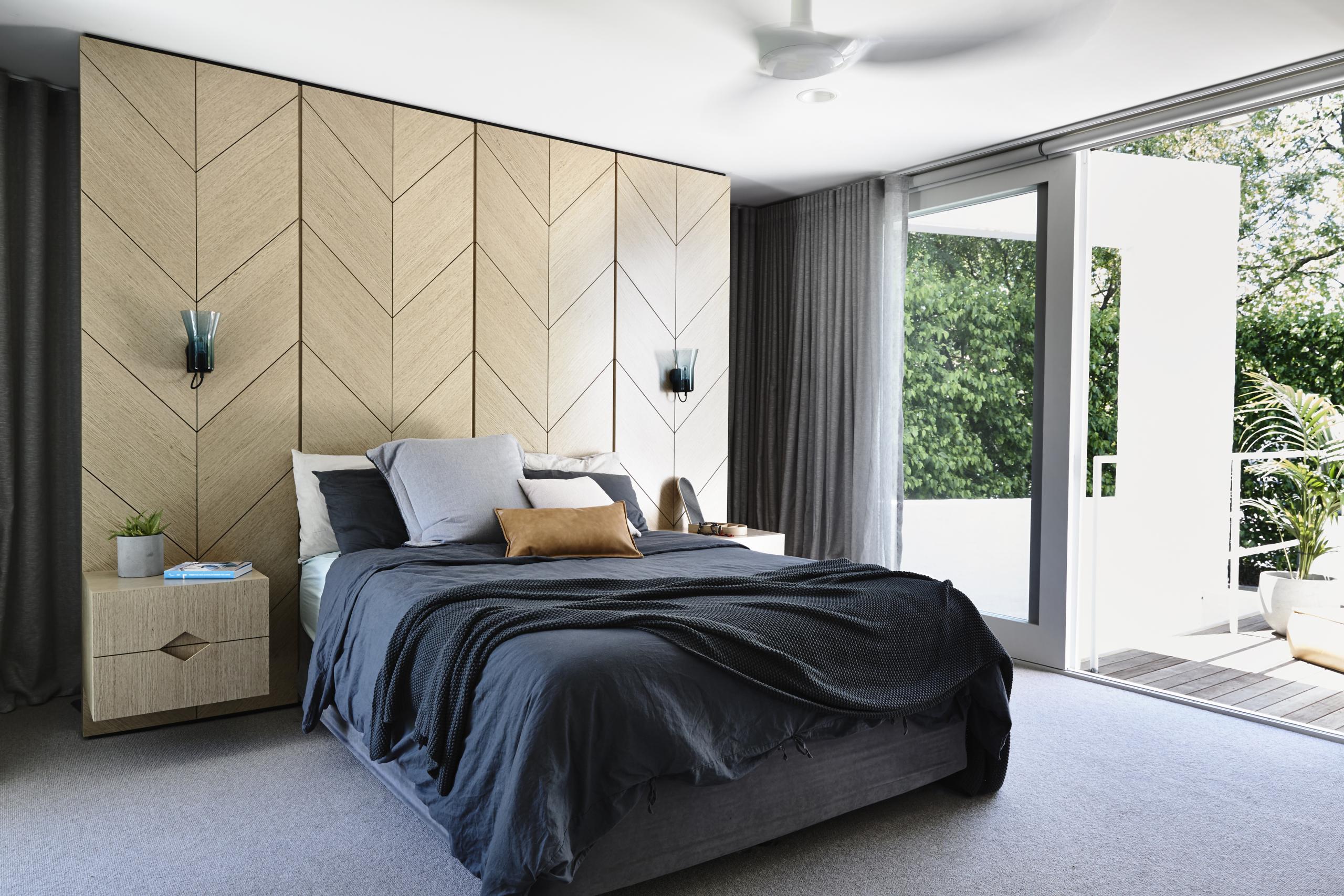 设计师在主卧墙壁装饰中选择了原木材质，配以灰色床品，空间散发出迷人的舒适感。