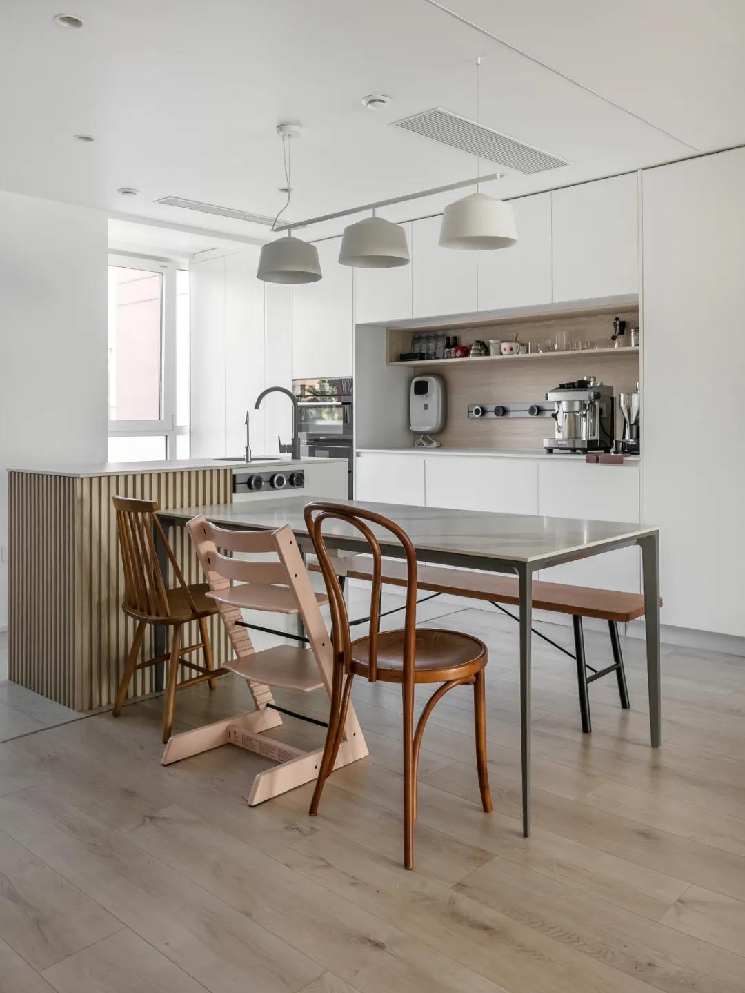 厨房餐厅一体化设计，配色较为的简洁，白色的墙壁搭配木质地砖，温馨感满满。