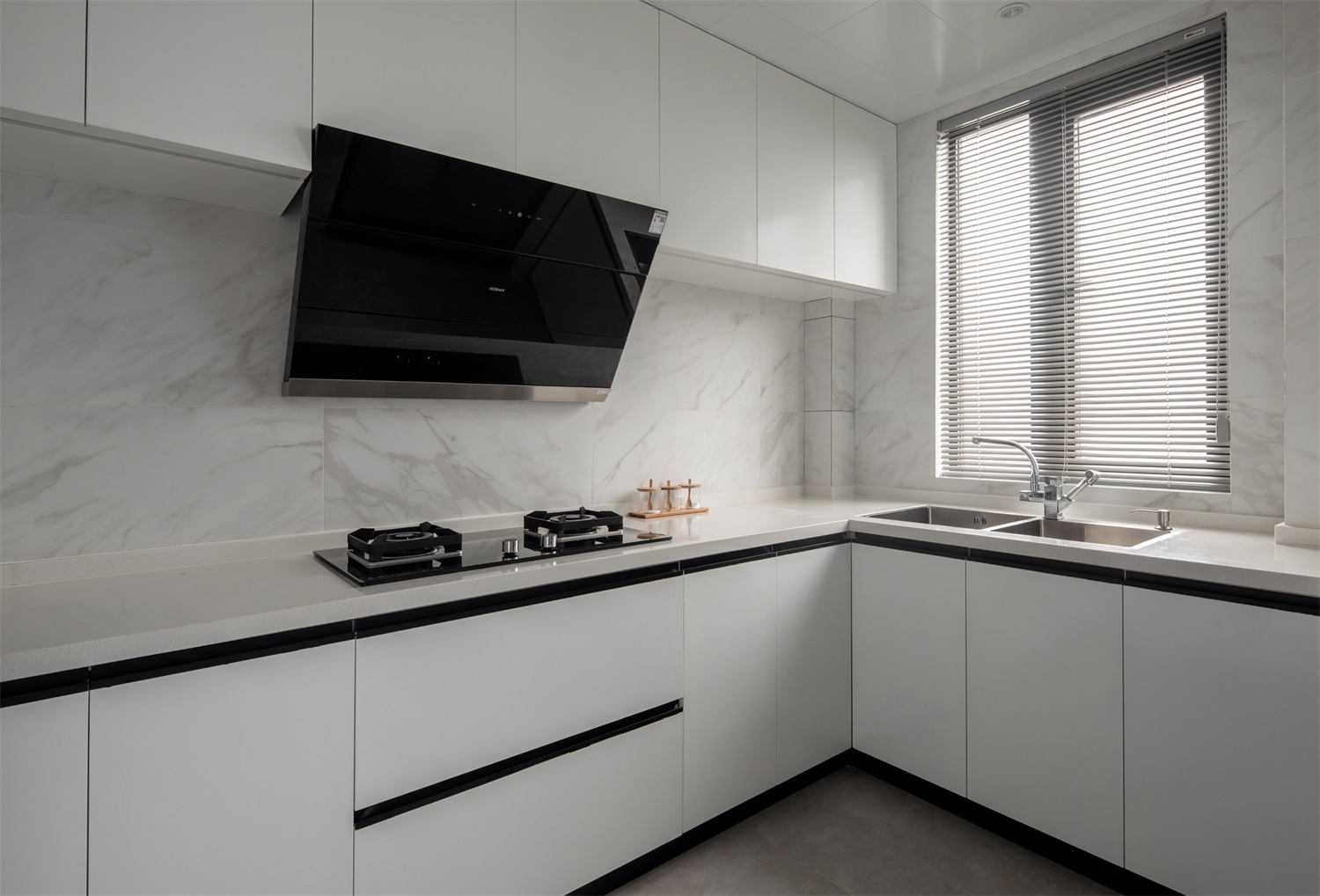 厨房以白色为空间主题，白色橱柜与白色工作台、大理石背景墙相得益彰。