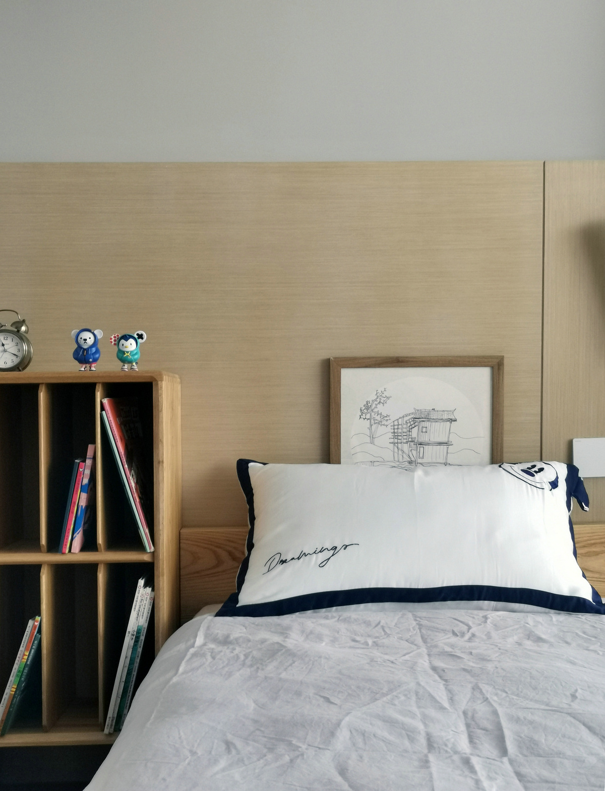 次卧设计素雅，木质面背景元素搭配浅色床品，呈现出北欧风格的唯美意境。