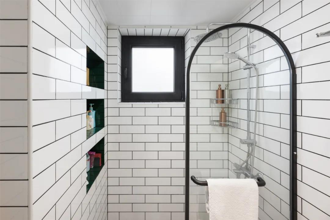 卫浴空间面积不大，为提升空间利用率，墙面采用了壁龛设计，中部则使用玻璃打造半隔断干湿分离。