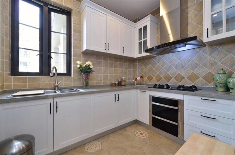厨房空间以米色和白色为主色调，结合花砖的设计，让空间显得更加明亮精致。