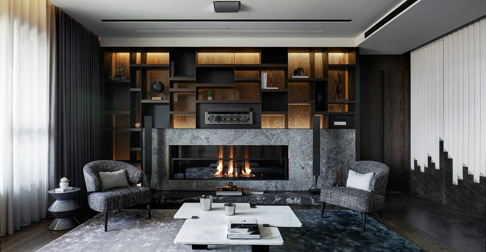 客厅以深灰色为主题，背景灯带赋予空间温暖而恬静的气质，使客厅更显灵动。