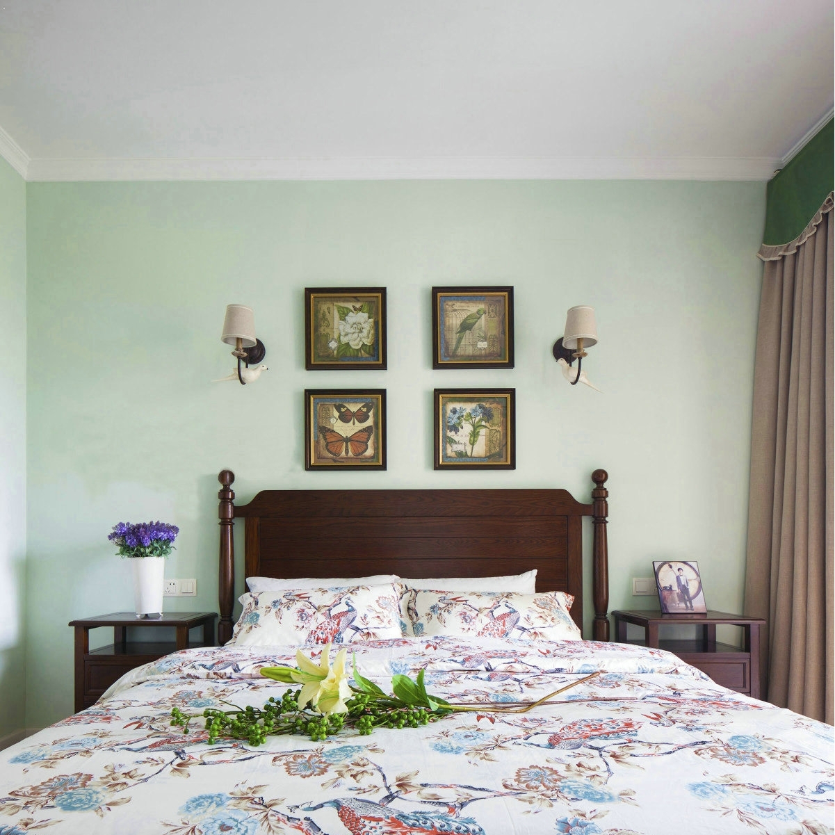 主卧以绿色为基调，搭配深棕色的家具，复古优雅。花鸟装饰画和鹦鹉壁灯为房间注入大自然的气息，空间更显灵