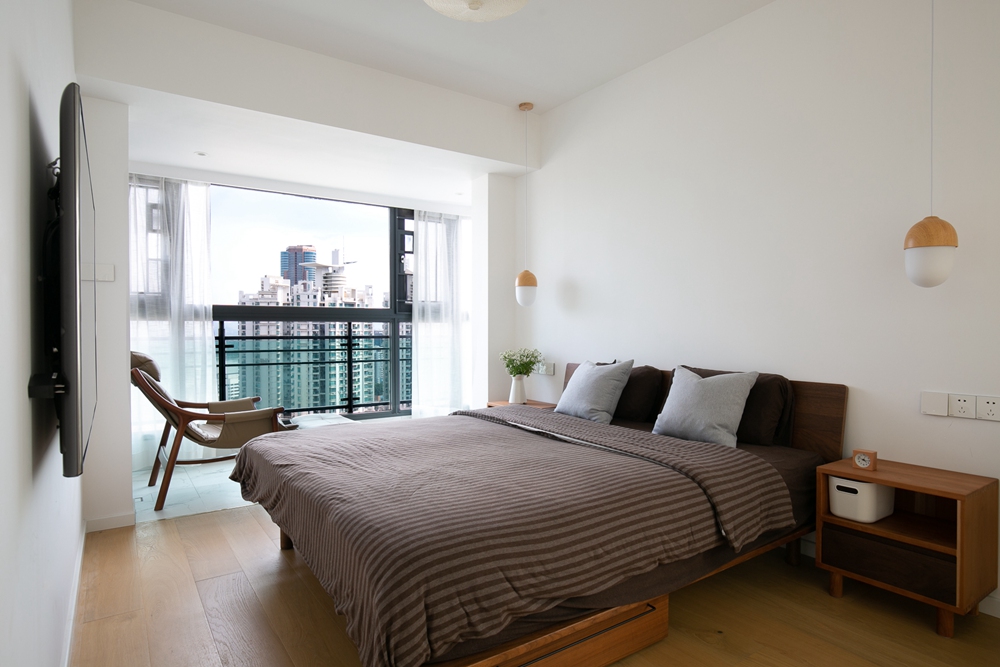 卧室在配置上使用白色背景墙设计，床头独特的垂吊灯具，使家具倍感时尚。