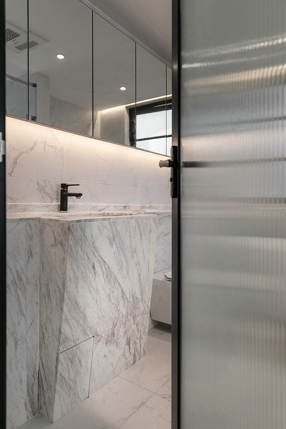 卫浴间设计紧凑，良好的采光使空间更加通透，白色洁具在大理石背景下营造出精致的氛围。
