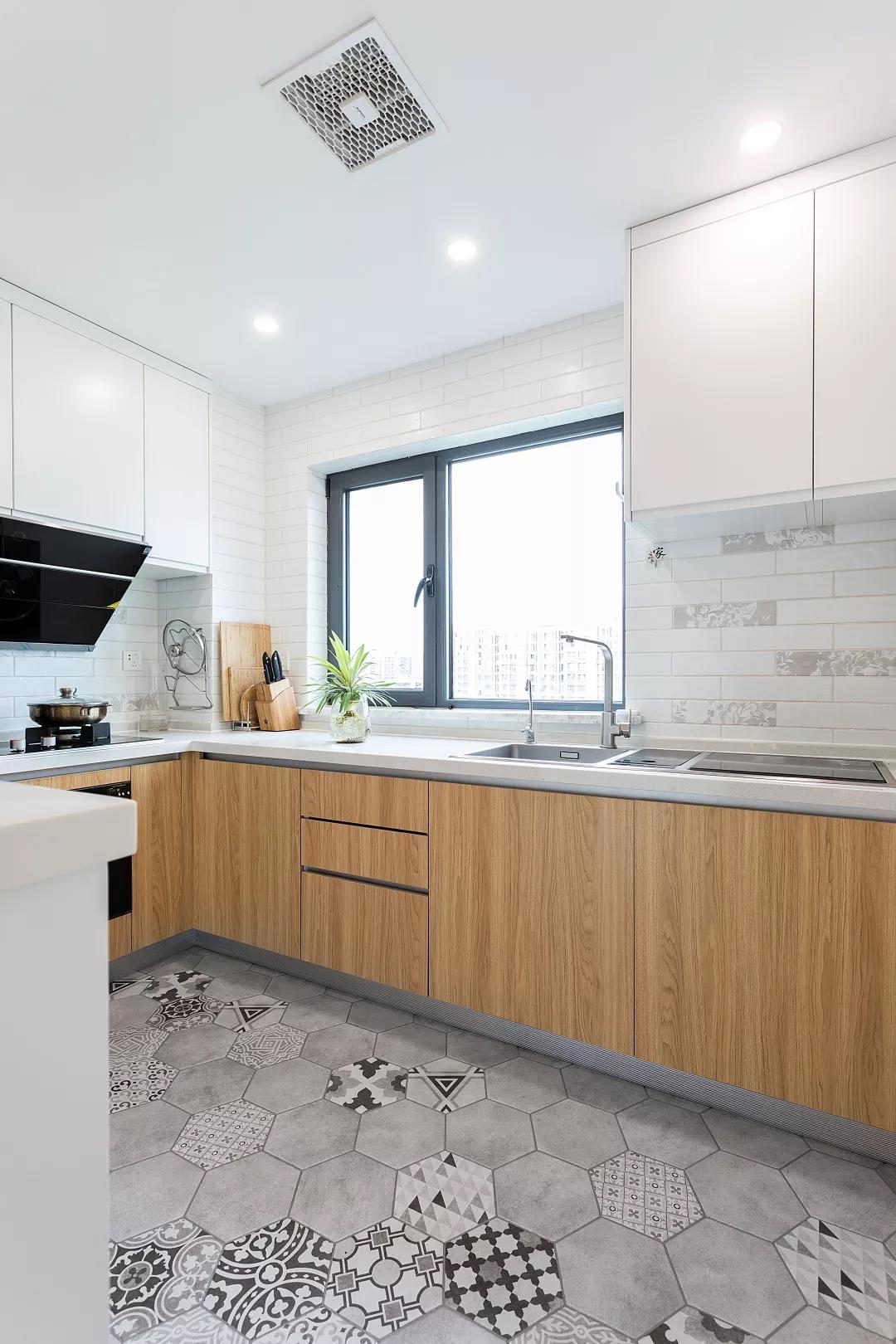 整个厨房空间的天花采取吊平顶的设计，橱柜选用木色橱柜，均匀明亮的照明设计提升温馨感。