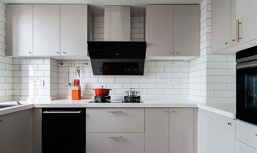 厨房以暖色为基调，·浅咖色橱柜搭配白色背景墙，营造出温馨舒适的氛围。
