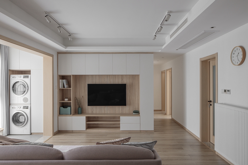 电视机背景墙质地纯净，白色收纳柜与木质材料相结合的方式，内敛和雅致。