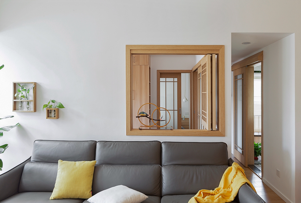 客厅采用大面积的原木设计，灰色皮质沙发与灰色卡座，使空间基调更稳定。