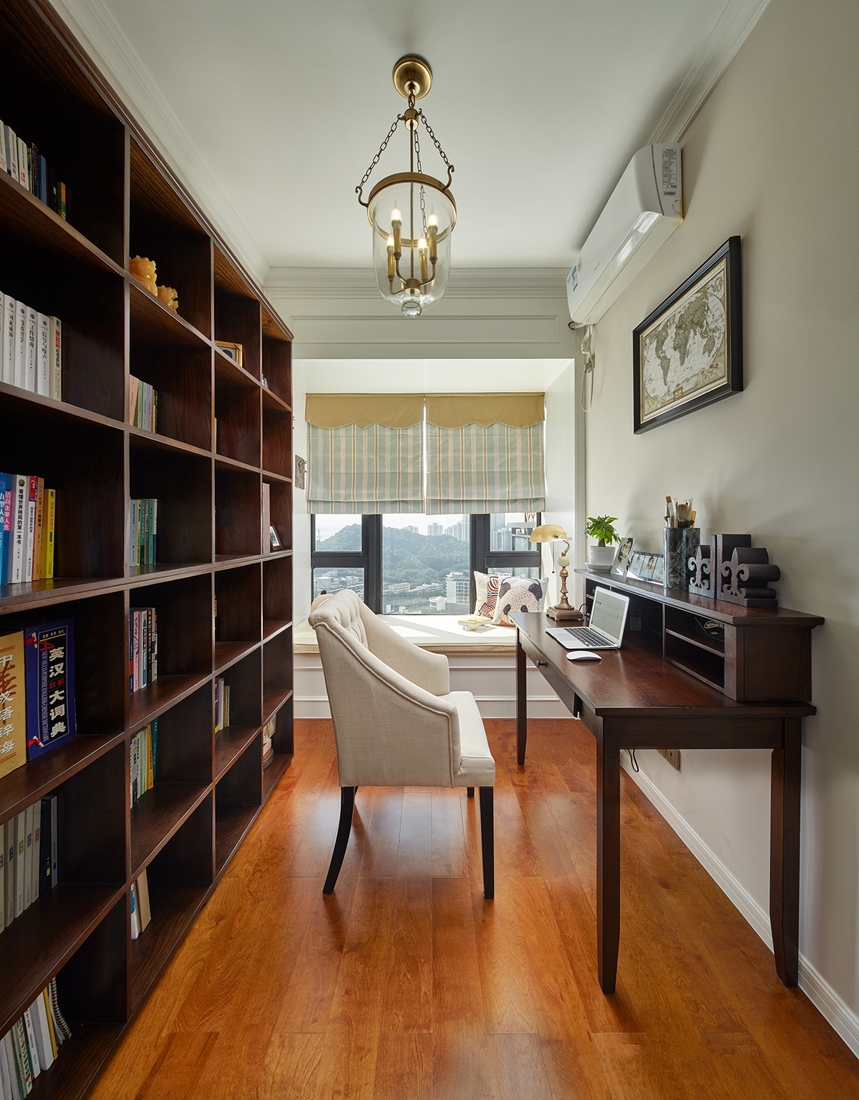 书房空间简约自然，设计师采用整面背景墙做书柜收纳，令房间看上去更有秩序。
