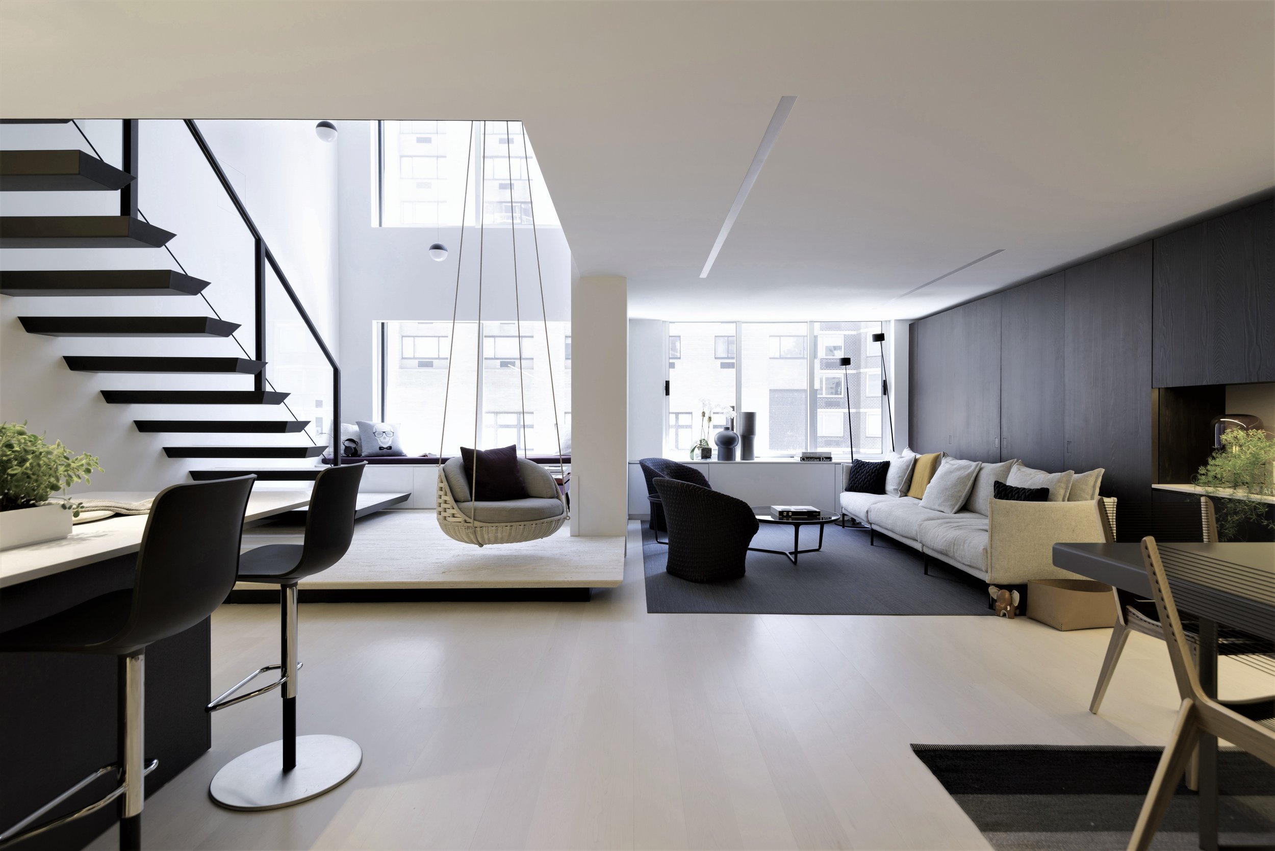 黑白背景下，布艺沙发成为了客厅里的点缀，搭配跳色抱枕，展现出浓厚的现代气息。