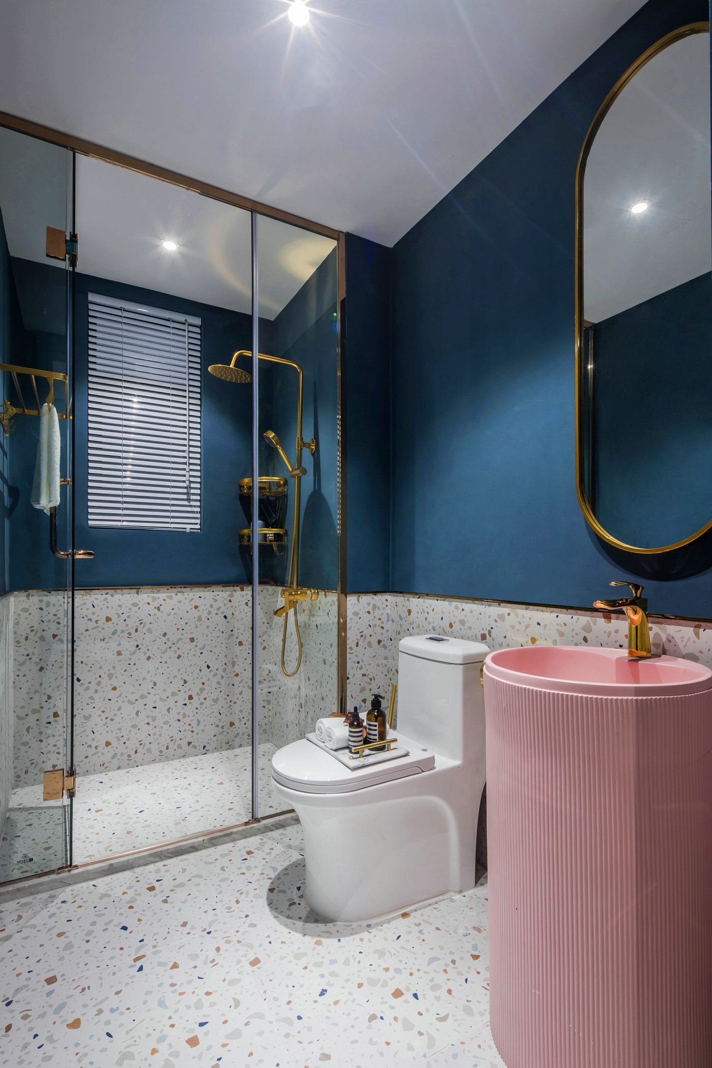 卫浴空间色感明亮舒适，粉色洗手池搭配蓝色背景，局部金属线条勾勒，充满自然活力。