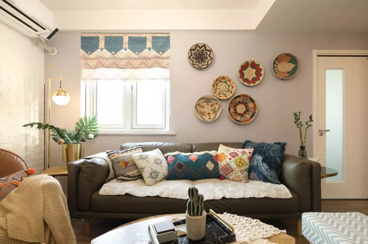 沙发是深色沉稳色调，罗马杆窗帘，墙面上花纹元素的盆子装饰，多个盘子组合在一起将时尚和个性诠释到位。