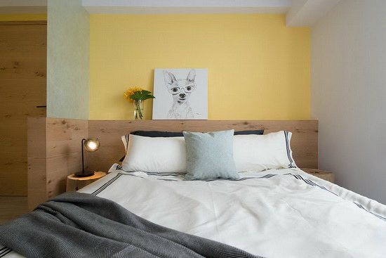 黄色作为床头背景墙，与木质床头形成对比，营造出空间层次的丰富性。