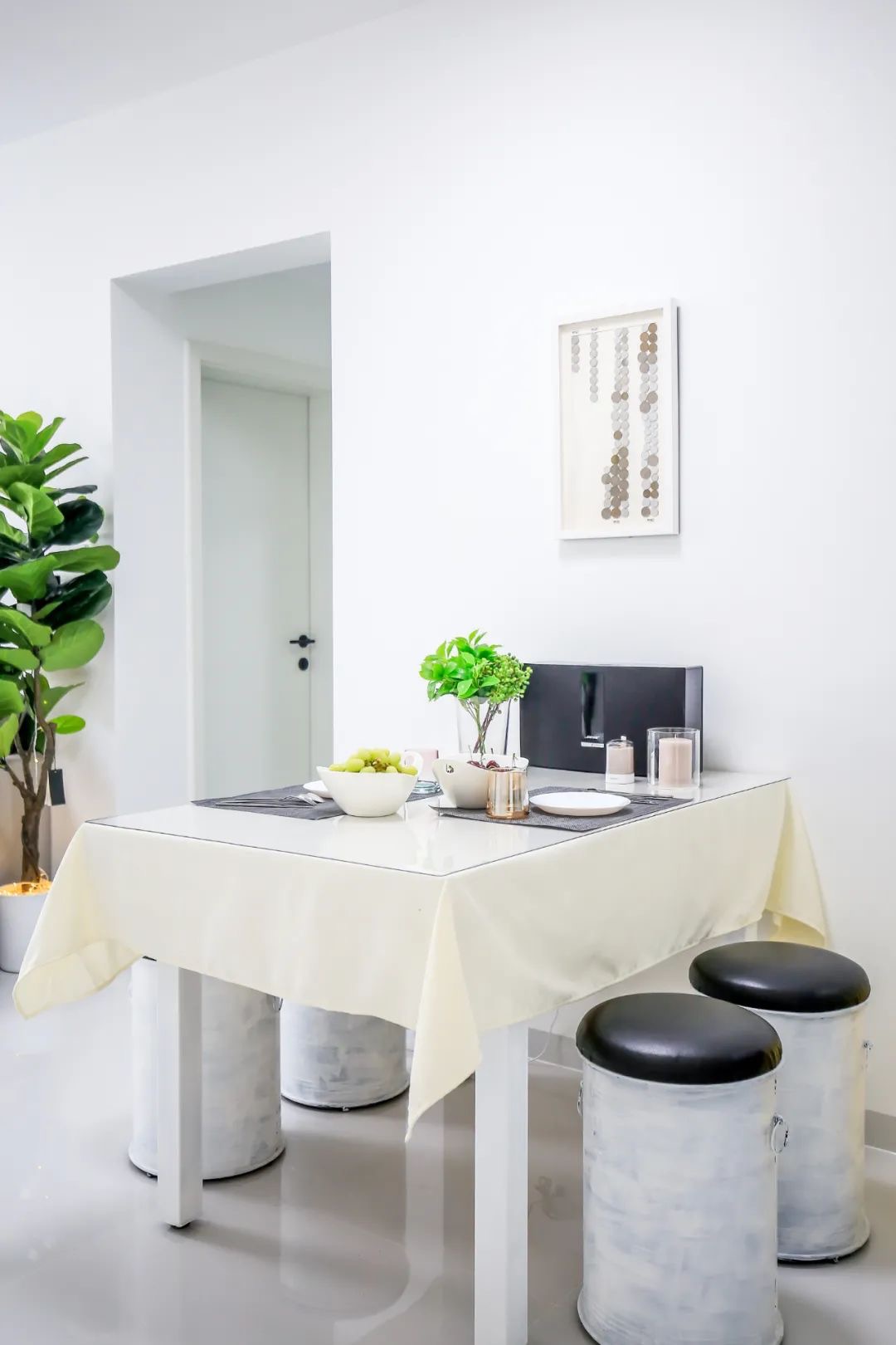 白色方形餐桌搭配圆凳餐椅，体现出简约的现代用餐氛围特点，静谧感十足。