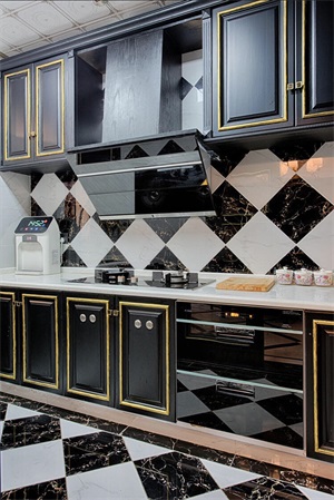 厨房使用黑白配色设计，黑色橱柜给人庄严尊贵的观感，金色线条的勾勒令空间更具层次感。