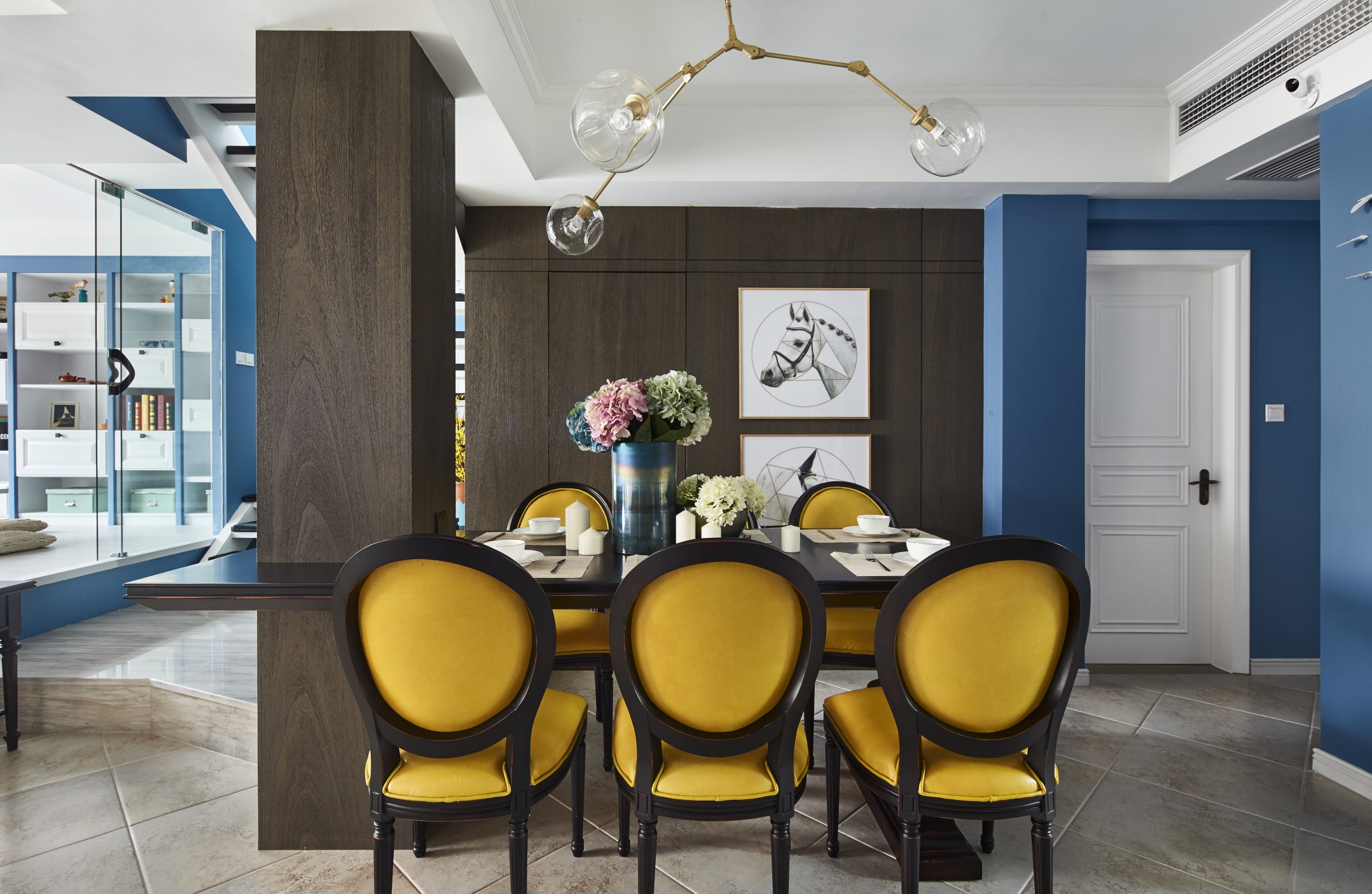 褐色木质餐桌搭配黄色餐椅，彰显欧式风格家具品味，分子结构灯饰与艺术挂画相辅相成。