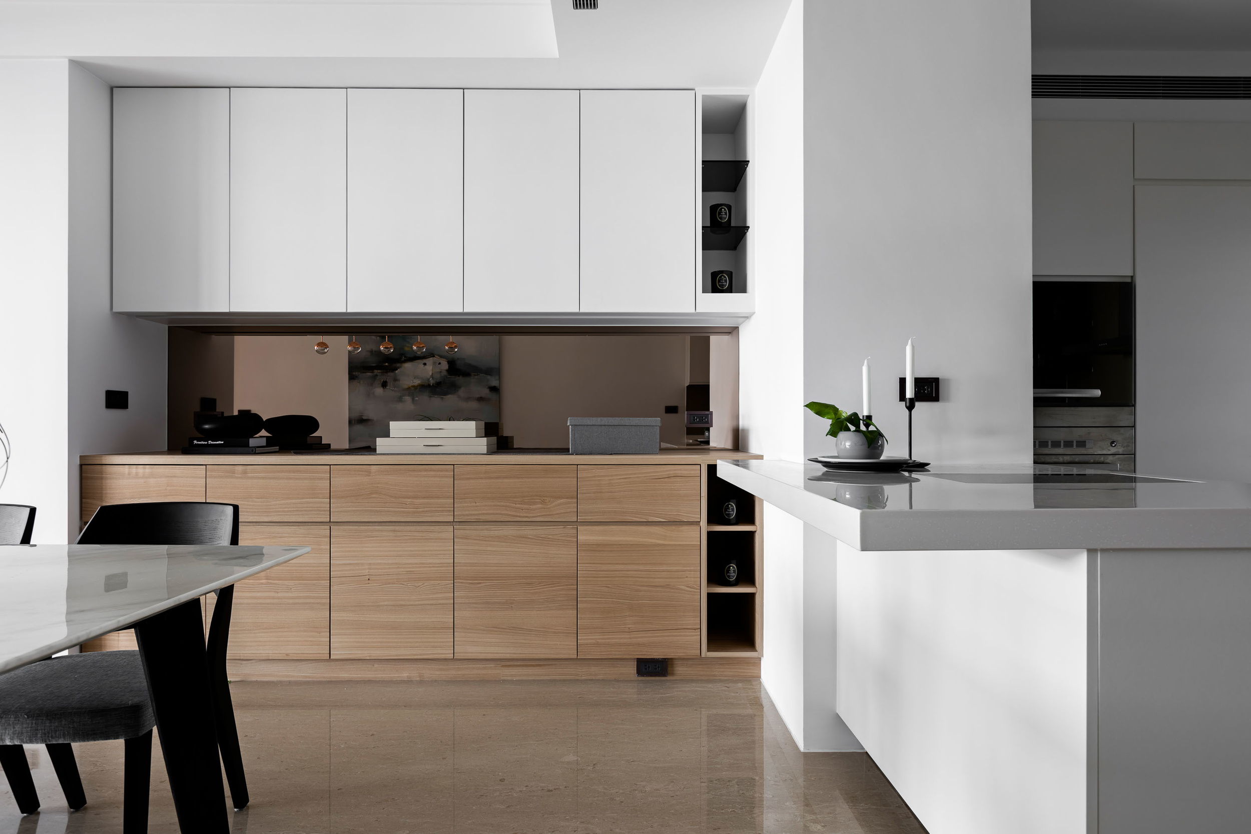 厨房空间以餐厅相连，白色与木色搭配，使厨房空间充满率性与质感。