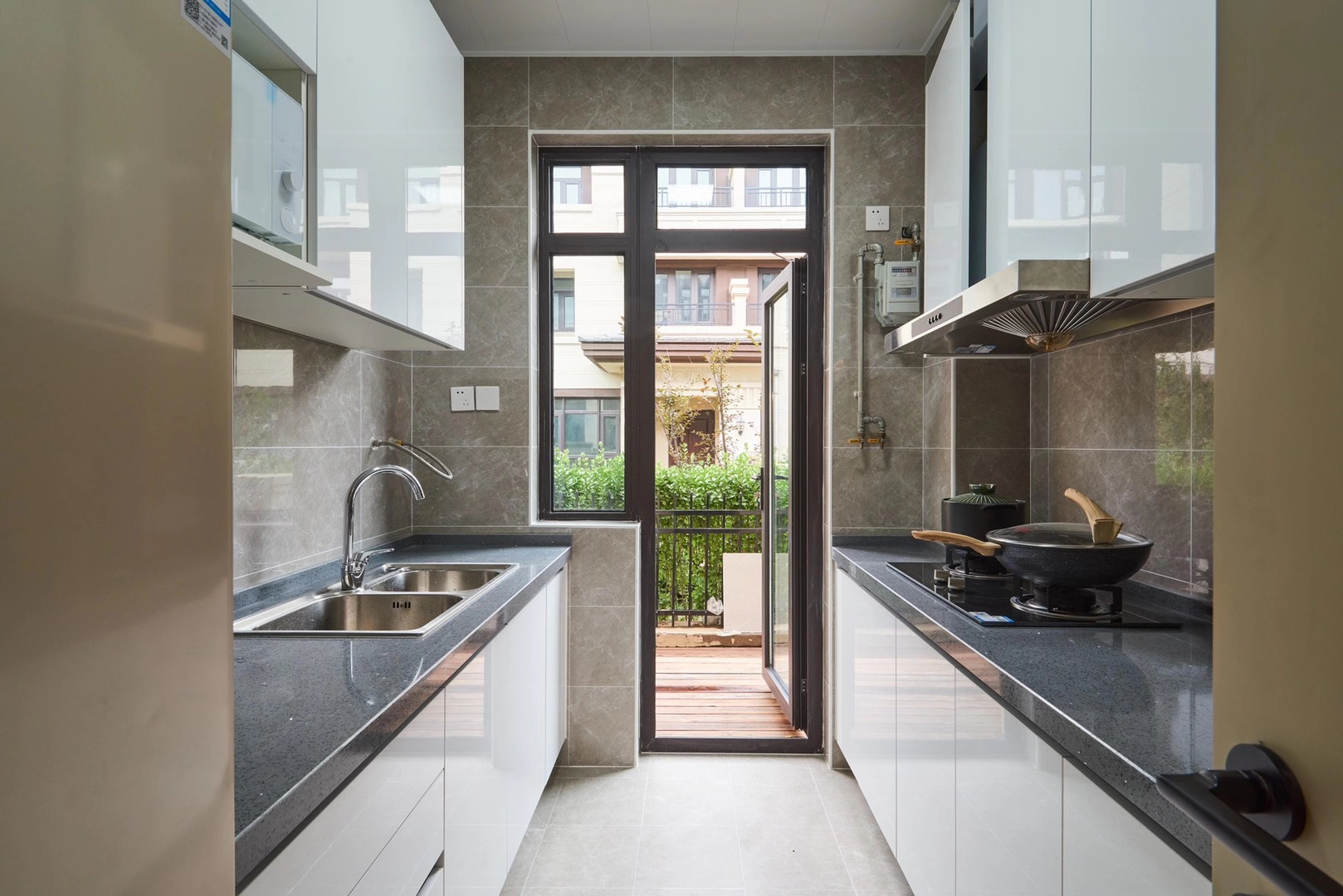 厨房以双一字型打造，动线设计完整，白色烤漆材质橱柜提升空间明亮度。