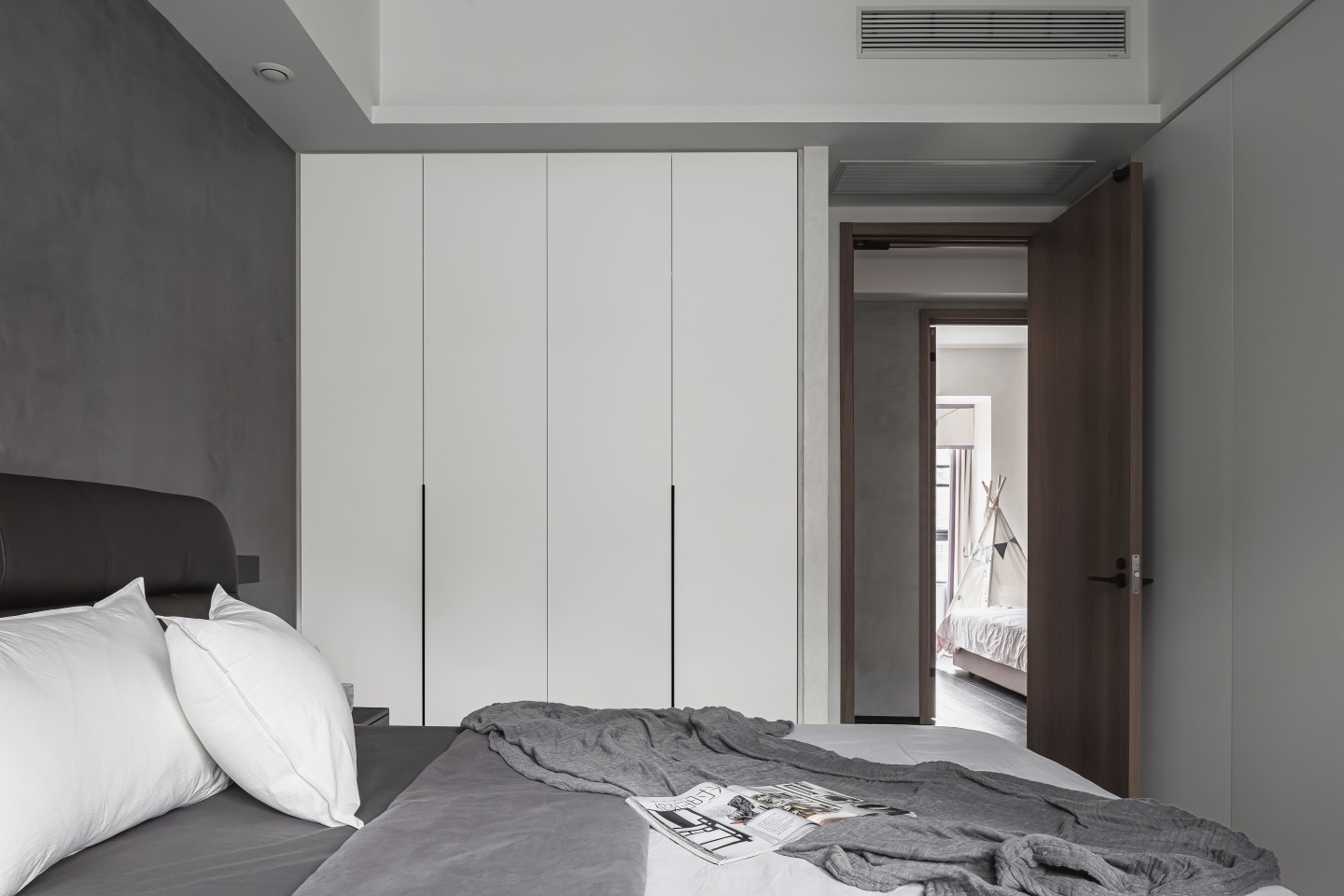 白色嵌入式衣柜结合灰色背景墙，加之无主灯的设计，空间显得更加敞亮。