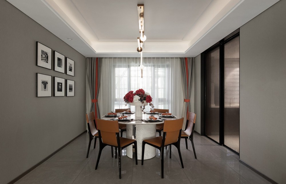 餐厅背景墙沿用灰色基调，橘色皮质餐椅成为空间色感点缀，营造出雅致的用餐氛围。