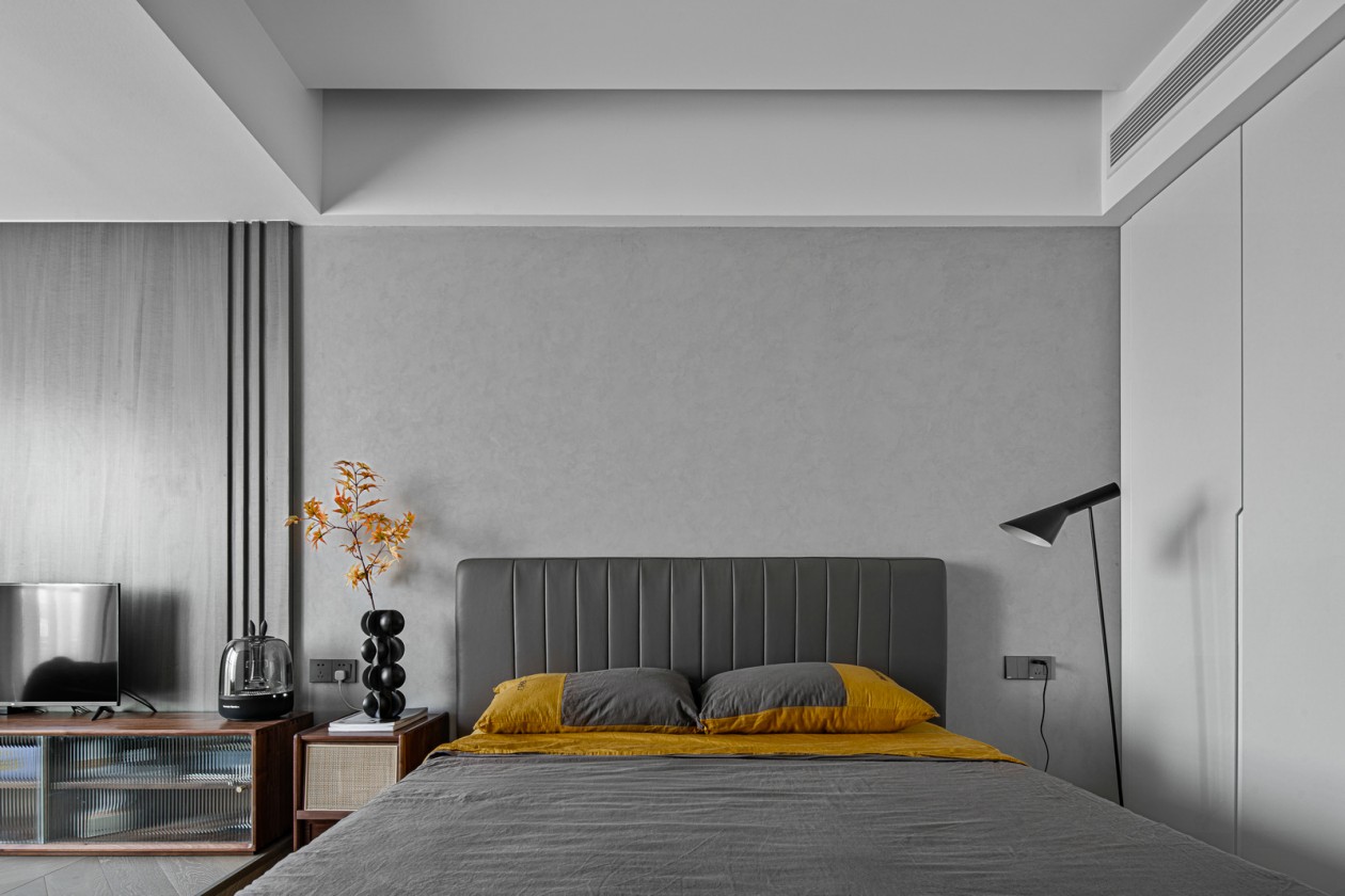 主卧配色纯净，灰色背景墙搭配深灰色床头设计，营造出工业质感。