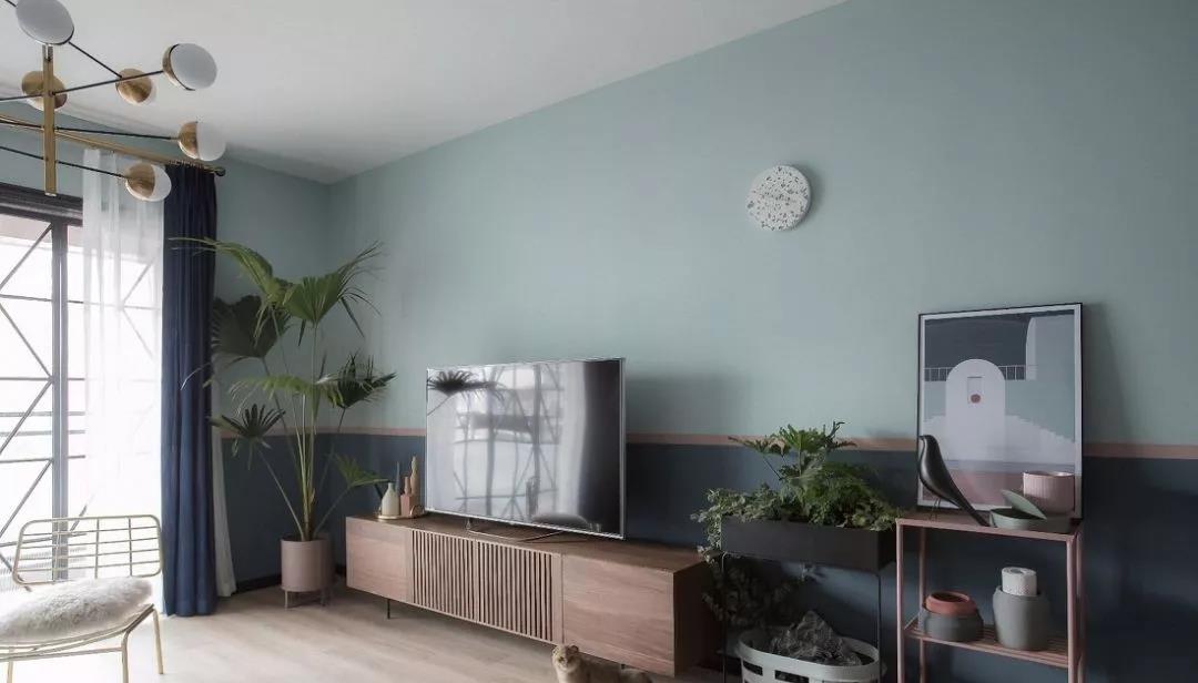 电视机背景墙素雅干净，局部使用绿植点缀，奠定空间的温暖、治愈的氛围。