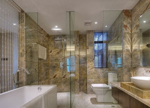 卫生间简约精致，背景墙以金色大理石铺贴，干湿分离设计完整，营造出高级感。
