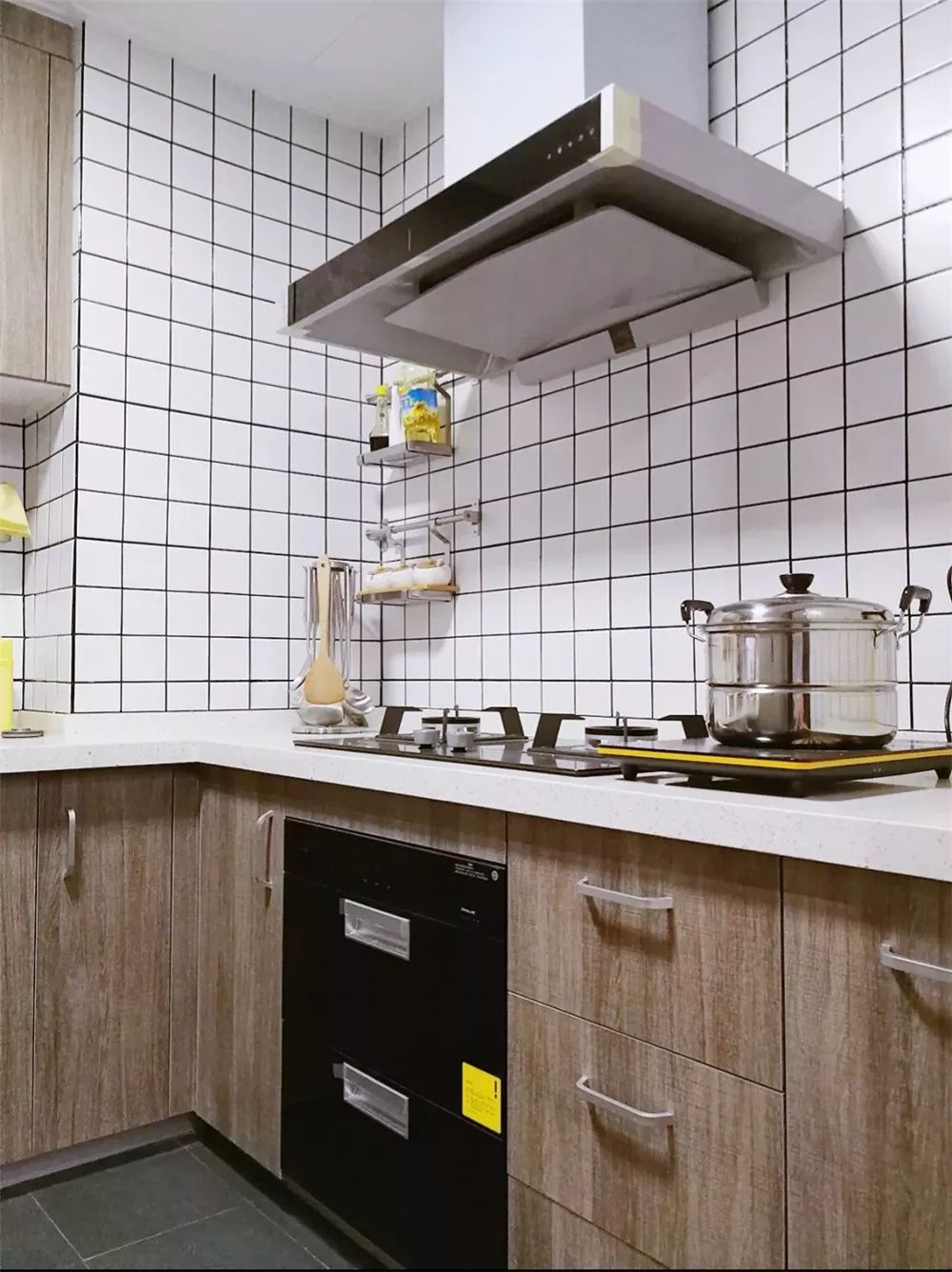 厨房墙面铺贴白色的九宫格瓷砖，让这个空间显得明亮且干净。