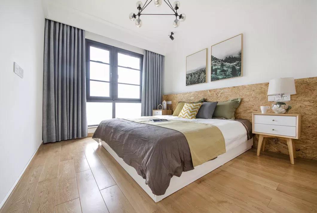 卧室地面铺设木地板，床头墙采用木材与白色分色设计，让卧室显得简约舒适。