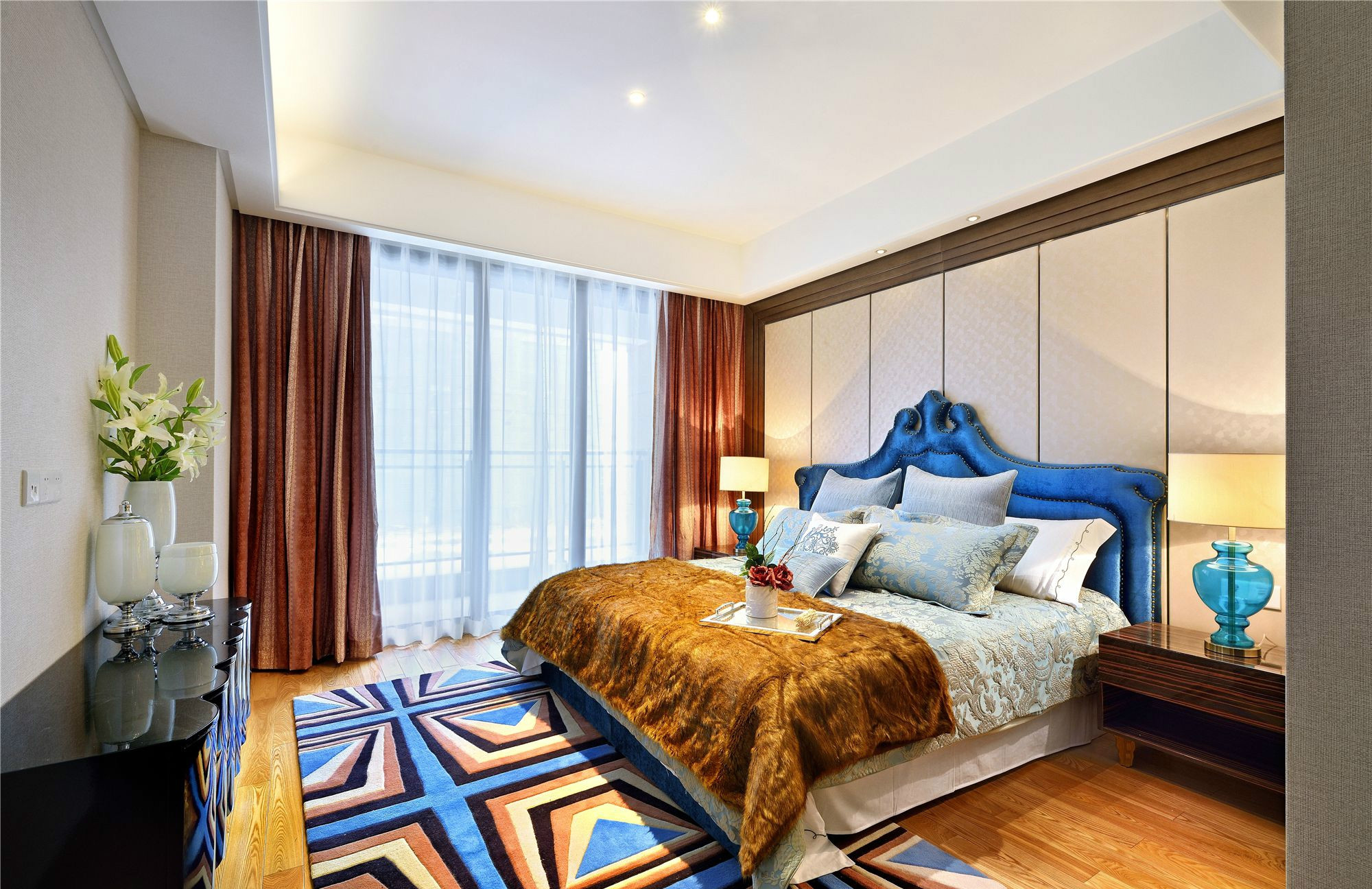 主卧米白色作为床头背景墙，与蓝色床头形成对比，营造出空间层次的丰富性。