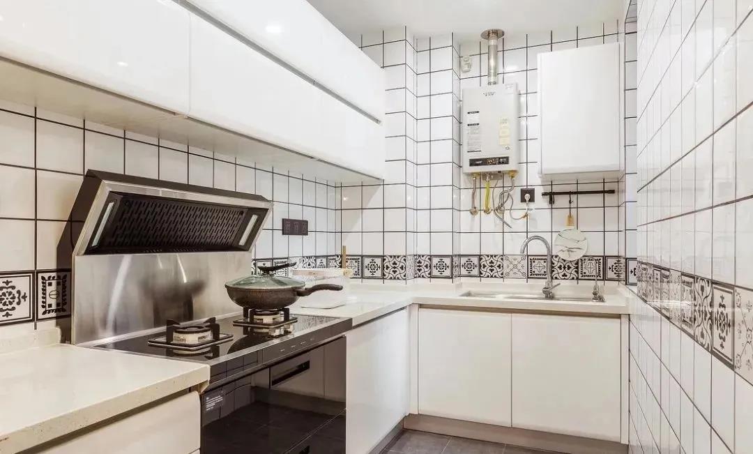 厨房选择白色橱柜打造，保留了烤漆材质本身的温润感，腰线瓷砖打破了空间沉闷感。