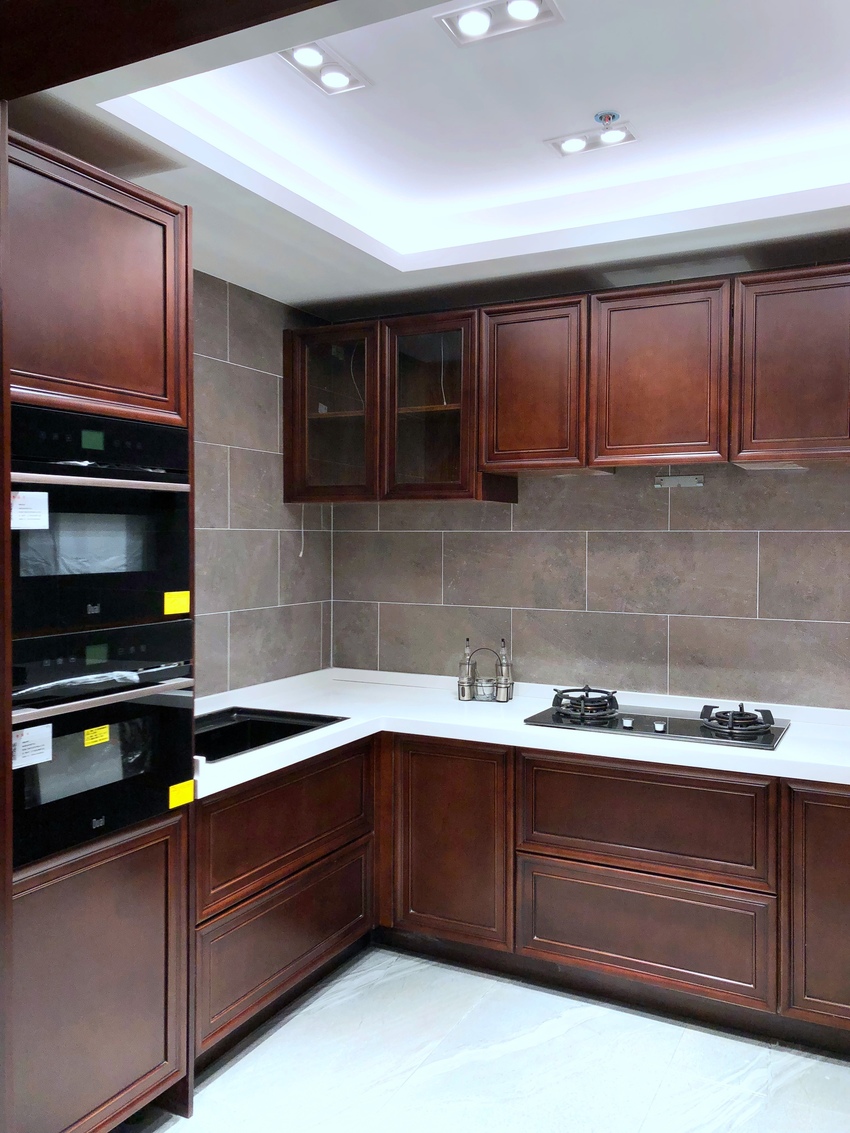 厨房布局明朗，红木橱柜呈现出新中式文化韵味，搭配白色工作台，空间舒适而大气。