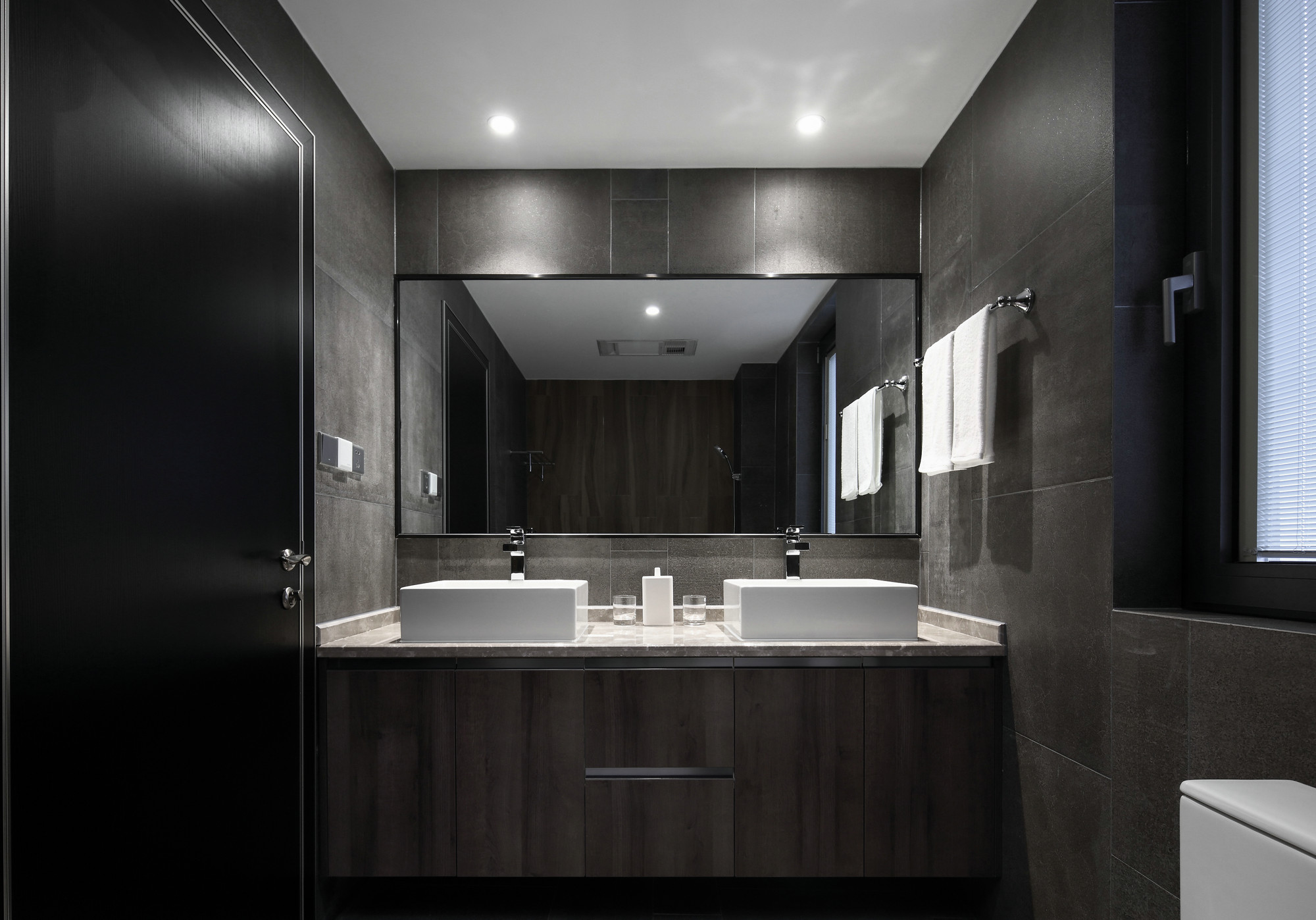 卫生间以咖色为主基调，白色洗手池在灯光的照射下， 更显安静与舒适。