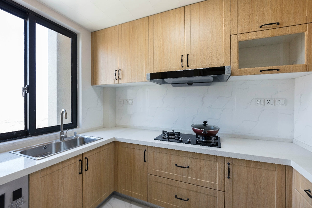 厨房空间在色彩上以木色和白色为主，动线规划完整，空间显得有序稳重。
