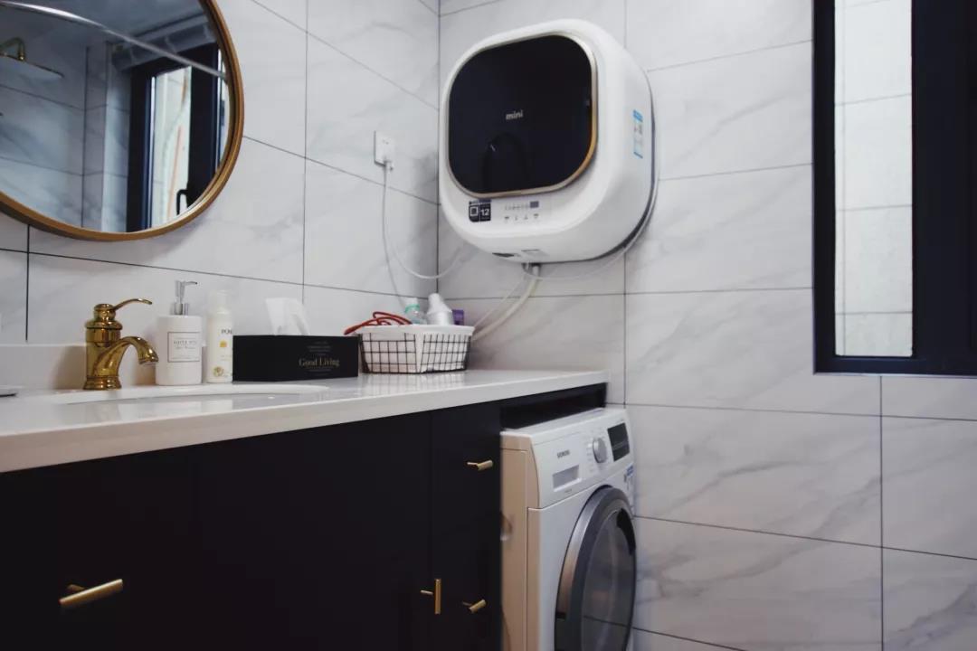 卫生间内的瓷砖铺贴使用白色，局部放置洗衣机，提升室内的使用功能。