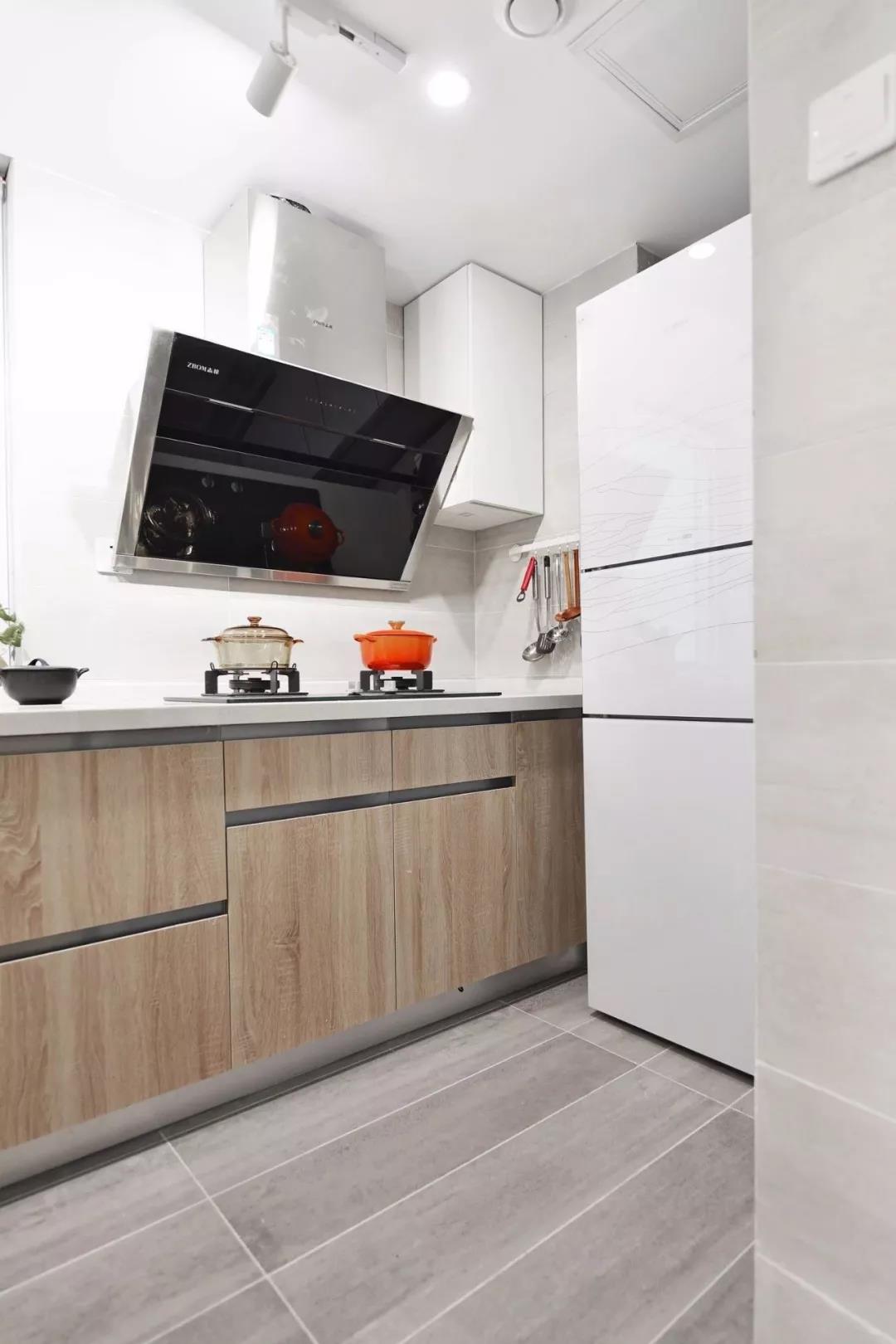 厨房使用白色基调打造，木质橱柜在空间中展现出简雅、素雅的气质。