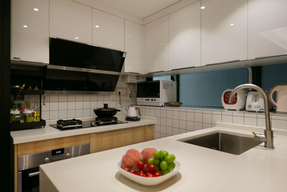 厨房以白色为主，加以亮色款式的烤漆橱柜点缀，使得空间更加洁净明亮。