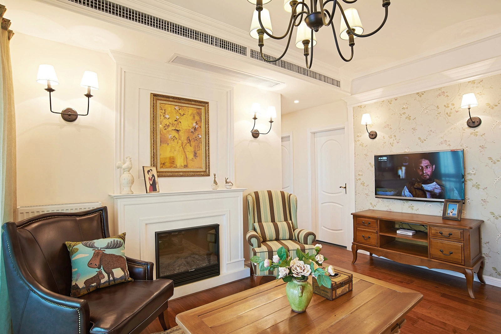 客厅简单的素色墙面，少量的墙面装饰，自然的绿色植物，以及布艺沙发和白色，构成了这个舒适现代简约之感