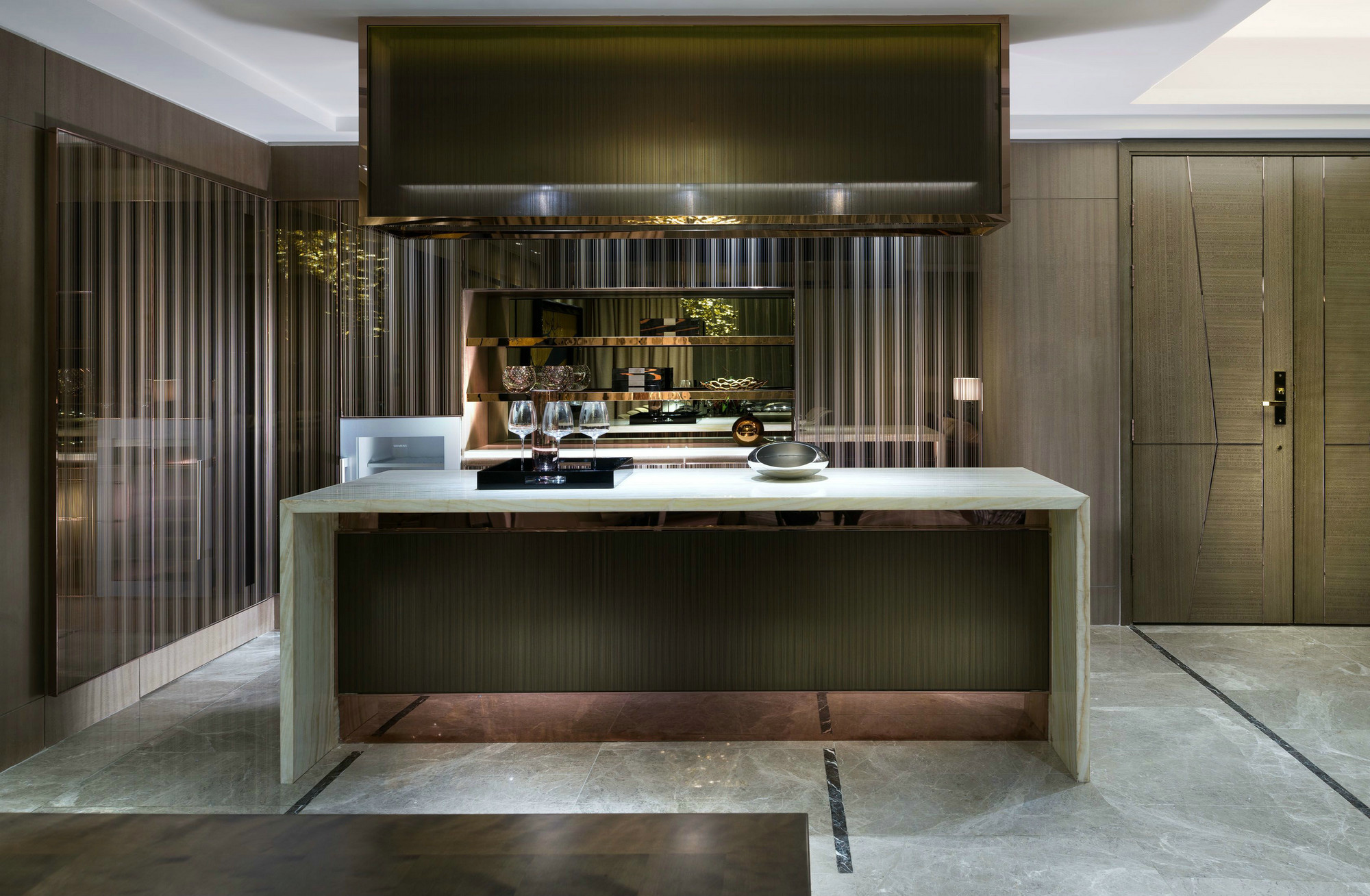 厨房以玻璃为背景，橱柜与空间整体相呼应，局部打造了白色吧台，营造出沉静感。
