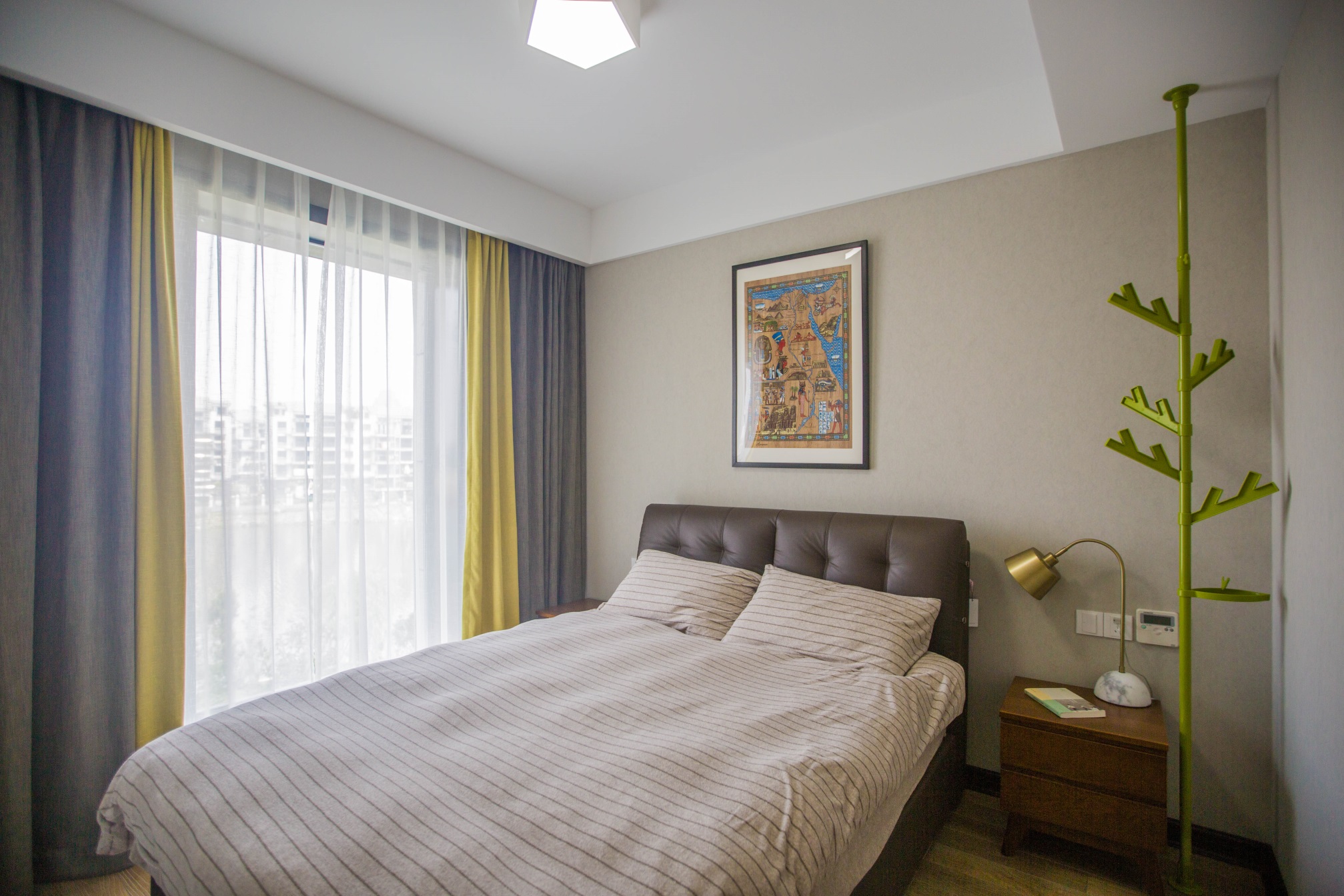 浅米色背景墙给人带来理性的美感，床头皮质软包简洁大方，空间硬朗整洁。