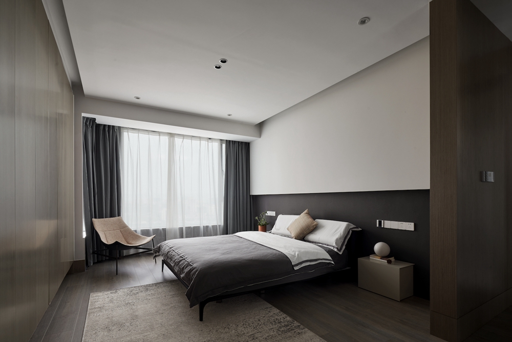 侧卧以咖色为主，背景墙以经典的黑白配设计，与床品相得益彰，空间简洁安静。
