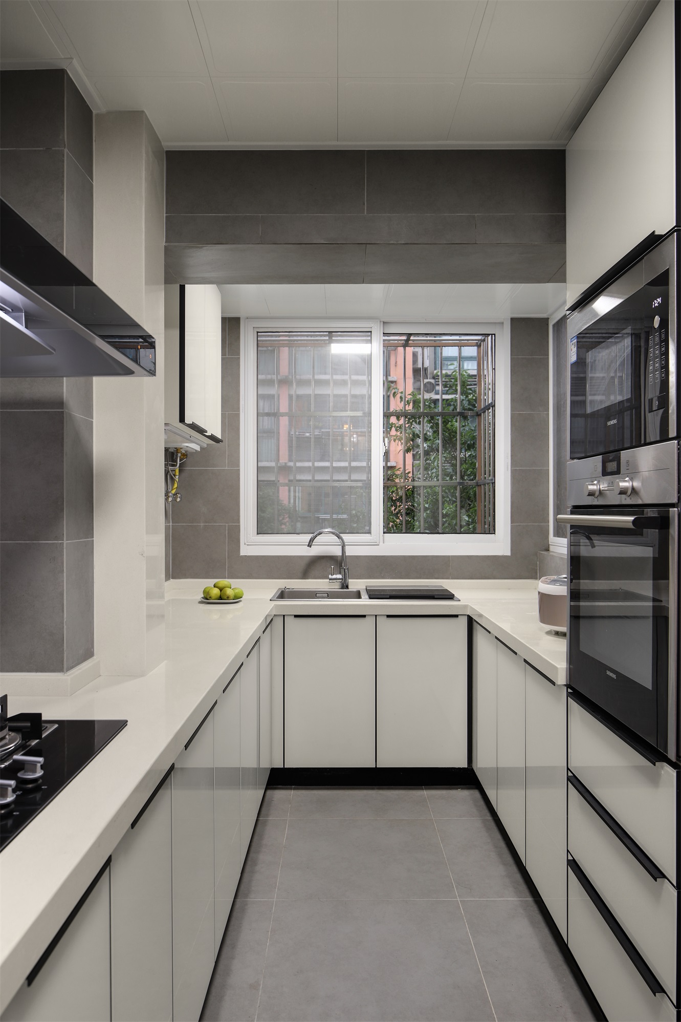 厨房整体充满了现代感，白色橱柜精致舒适，增加了烹饪空间的通透性。